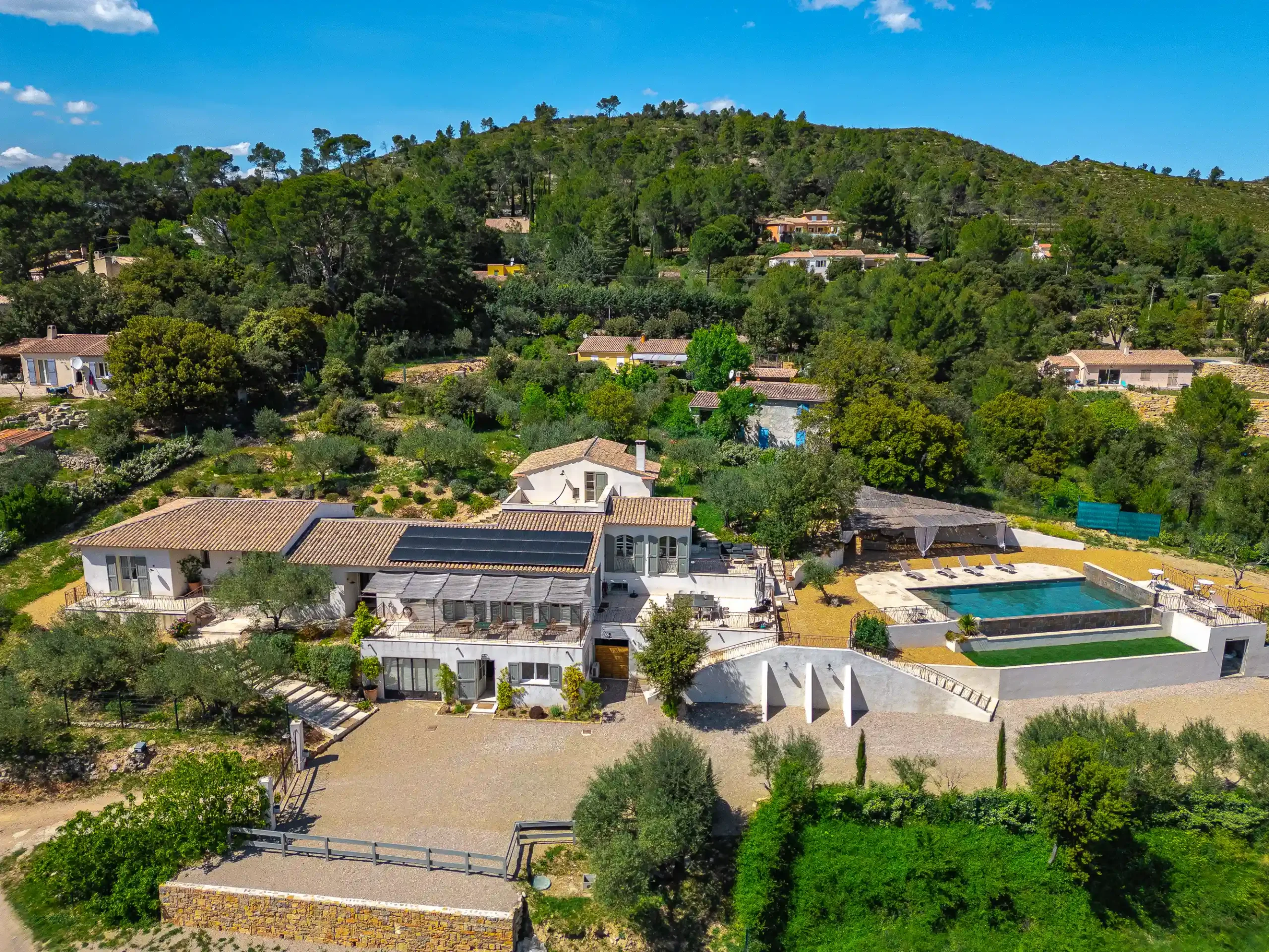 Domaine de la bastide vu par drone avec piscine turquoise, toits en tuiles et collines