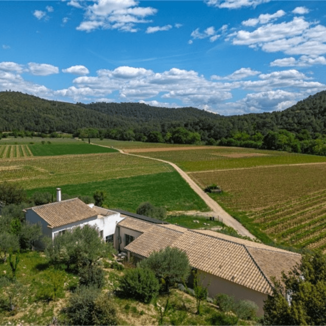 Villa aux toits en tuiles entourée de vignobles et de collines vus par drone