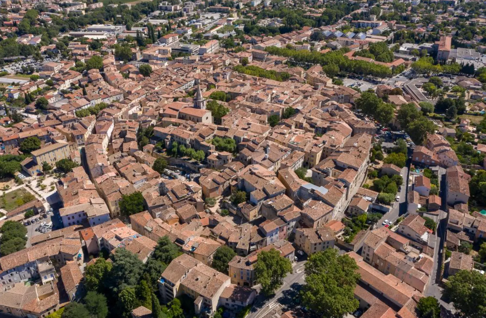 Vue aérienne du village de Brignoles en Provence, toits de tuiles ocres et clocher au milieu de la verdure