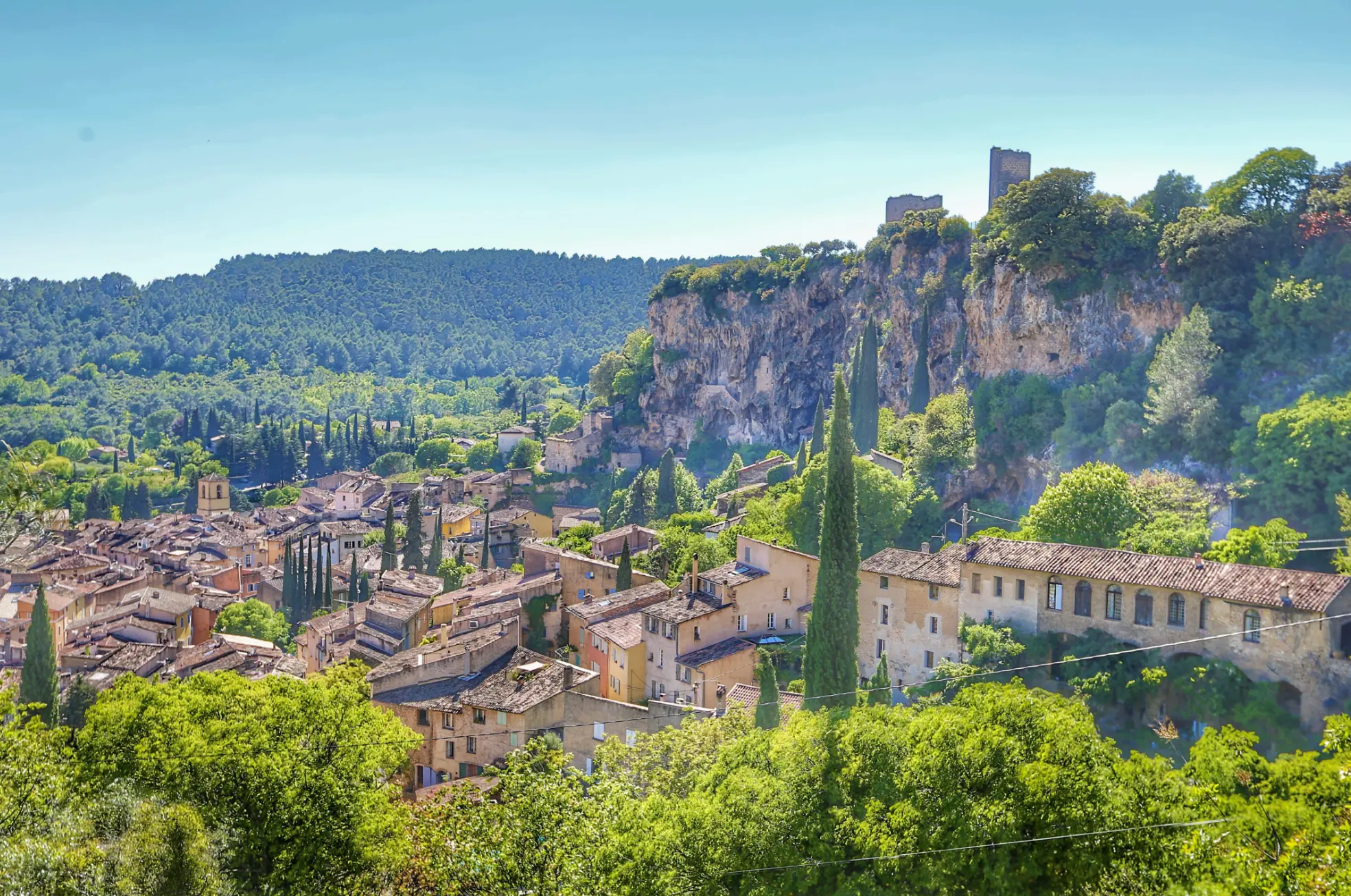 Village de Cotignac en Provence adossé à sa falaise ocre, rivière et verdure en contrebas
