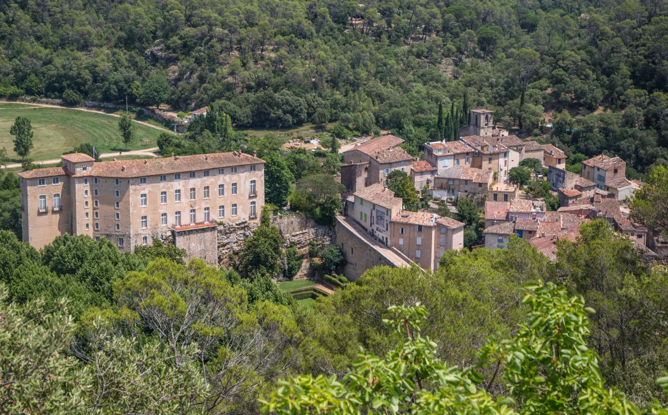 Vue aérienne du village perché d'Entrecasteaux en Provence, église et forêt méditerranéenne environnante